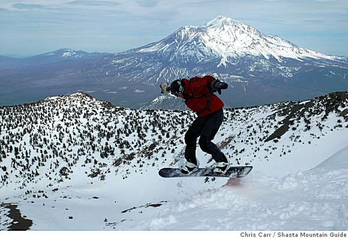 Chet Kyle snowboards over a jump at the summit of 9,025-foot Mount Eddy with 14,162-foot Mount Shasta looming to the east.