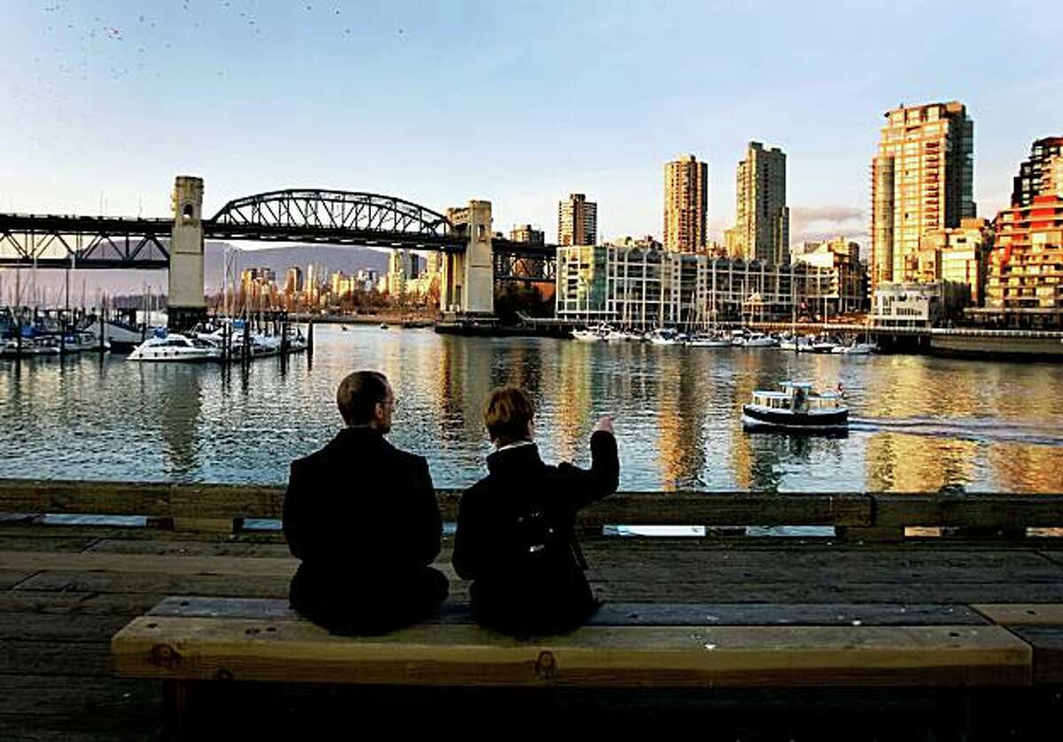 VANCOUVER, CANADA - FEBRUARY 18: A couple watch a ferry boat approach from thier seat on the Granville Island dock February 18, 2009 in Vancouver, British Columbia, Canada. Vancouver is the host city for the 2010 Winter Olympic Games being held February 12-28, 2010. (Photo by Robert Giroux/Getty Images)