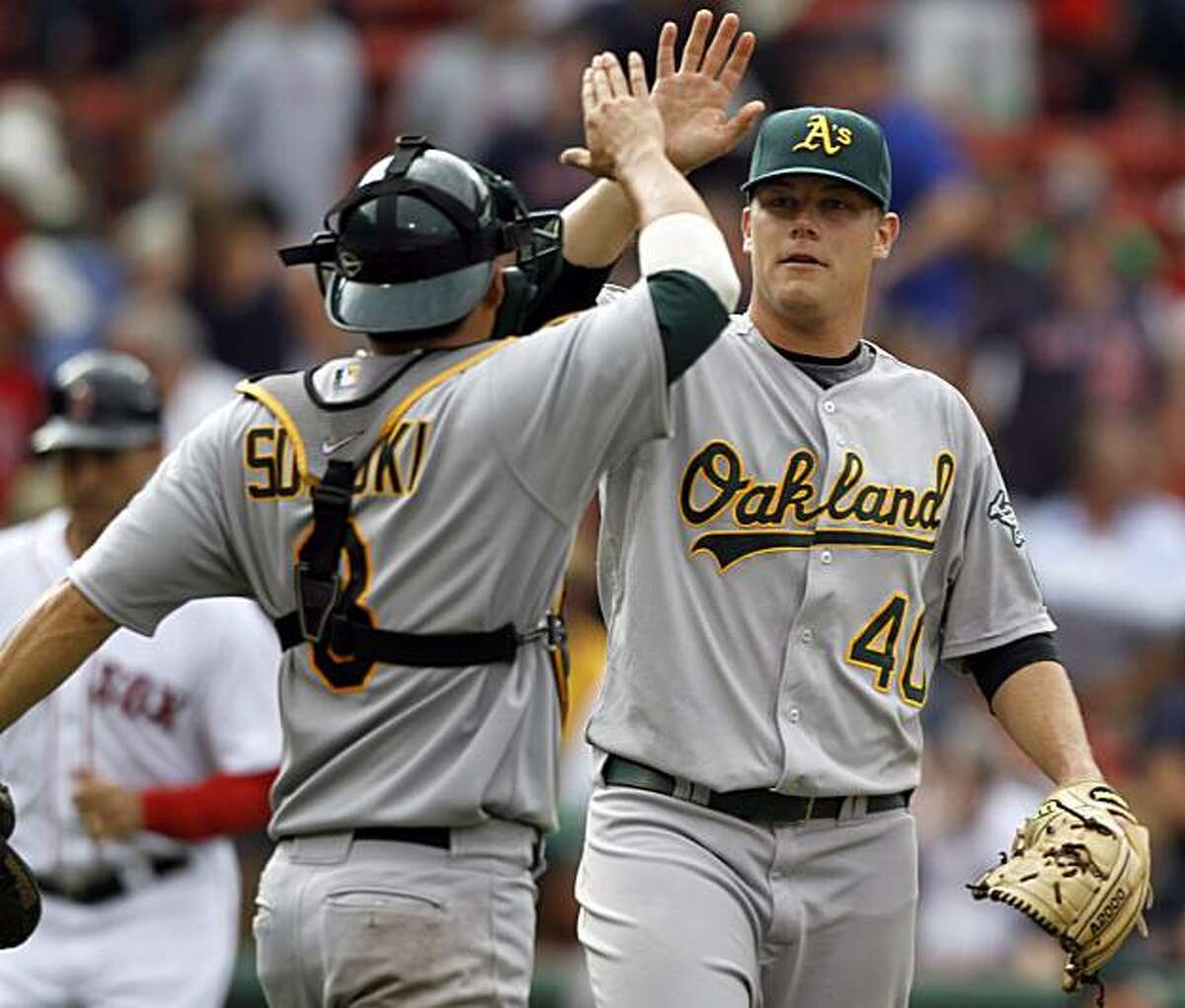 Oakland Athletics catcher Kurt Suzuki, left, and pitcher Andrew Bailey celebrate after the Athletics defeated the Boston Red Sox 9-8 in a baseball game at Boston's Fenway Park, Thursday, June 3, 2010.