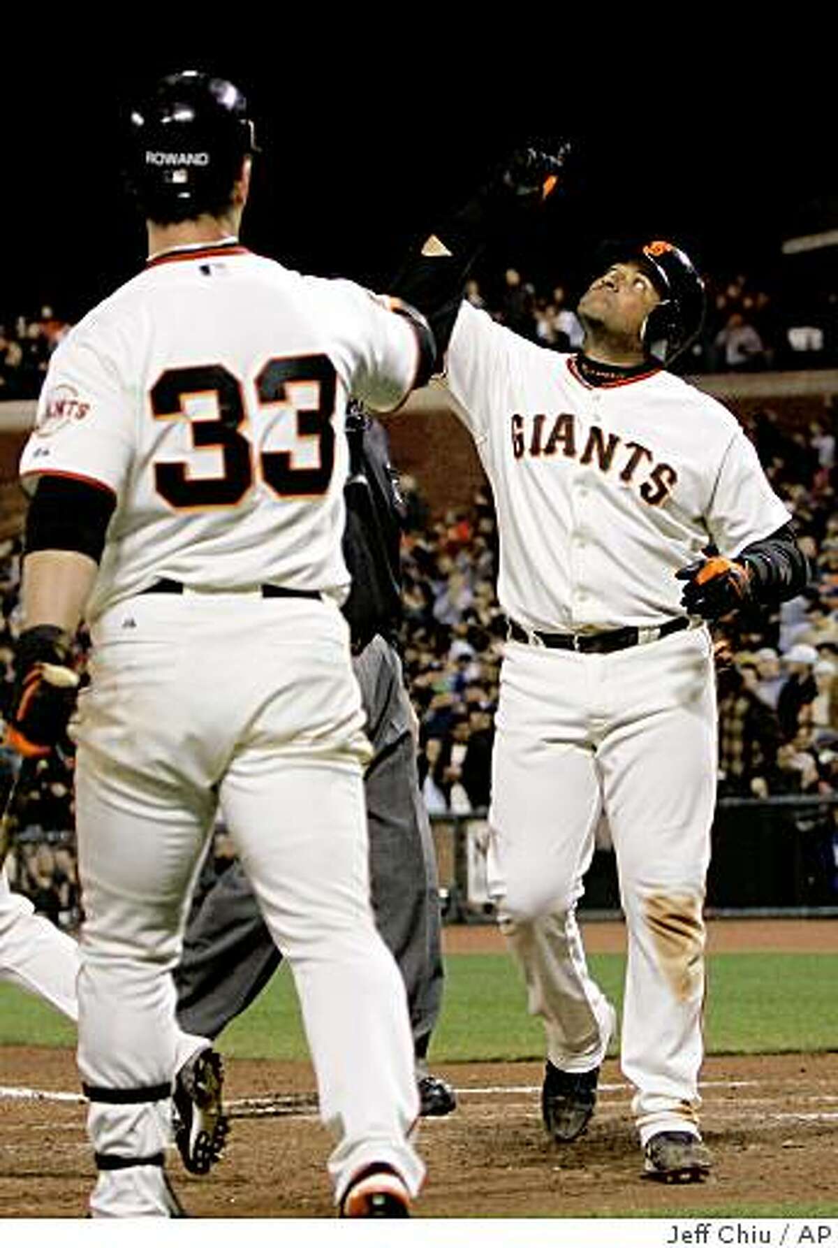 San Francisco Giants' Bengie Molina, right, celebrates after hitting a solo home run off of Los Angeles Dodgers' Scott Elbert in the seventh inning of a baseball game in San Francisco, Wednesday, April 29, 2009. At left is Giants' Aaron Rowand.