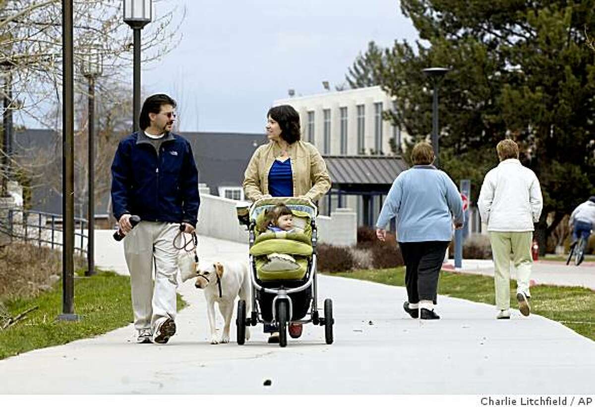 ** ADVANCE FOR SUNDAY, APRIL 26 **In this April 9, 2009 photo, Boise State University professor Michael Humphrey walks with his wife, Marcy, and their 2-year-old daughter, Annelise, and family dog along the west end of the university campus in Boise, Idaho. Humphrey is one of five faculty members at Boise State who live in residence halls to oversee both the personal and academic well being of the students. (AP Photo/Charlie Litchfield)