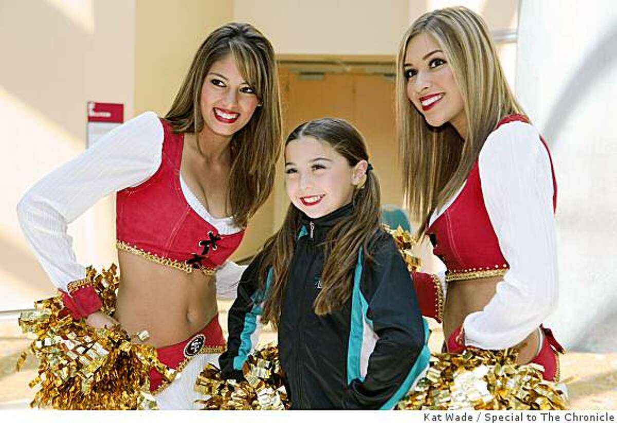 At the Convention center for a hip-hop dance competition, Genna Black, 10, takes the opportunity to pose with 49er cheerleader's Daffne, left, and Desiree, right, during the San Francisco 49ers NFL Draft Party at the Santa Clara Convention Center in Santa Clara, Calif. on Saturday, April 25, 2009.