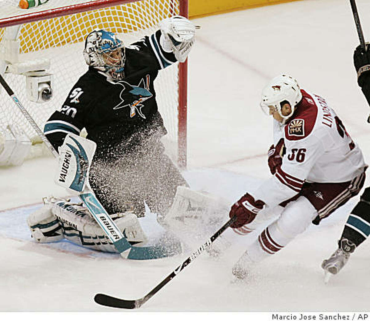 San Jose Sharks goalie Evgeni Nabokov, left, stops a shot from Phoenix Coyotes left wing Joakim Lindstrom during the first period.