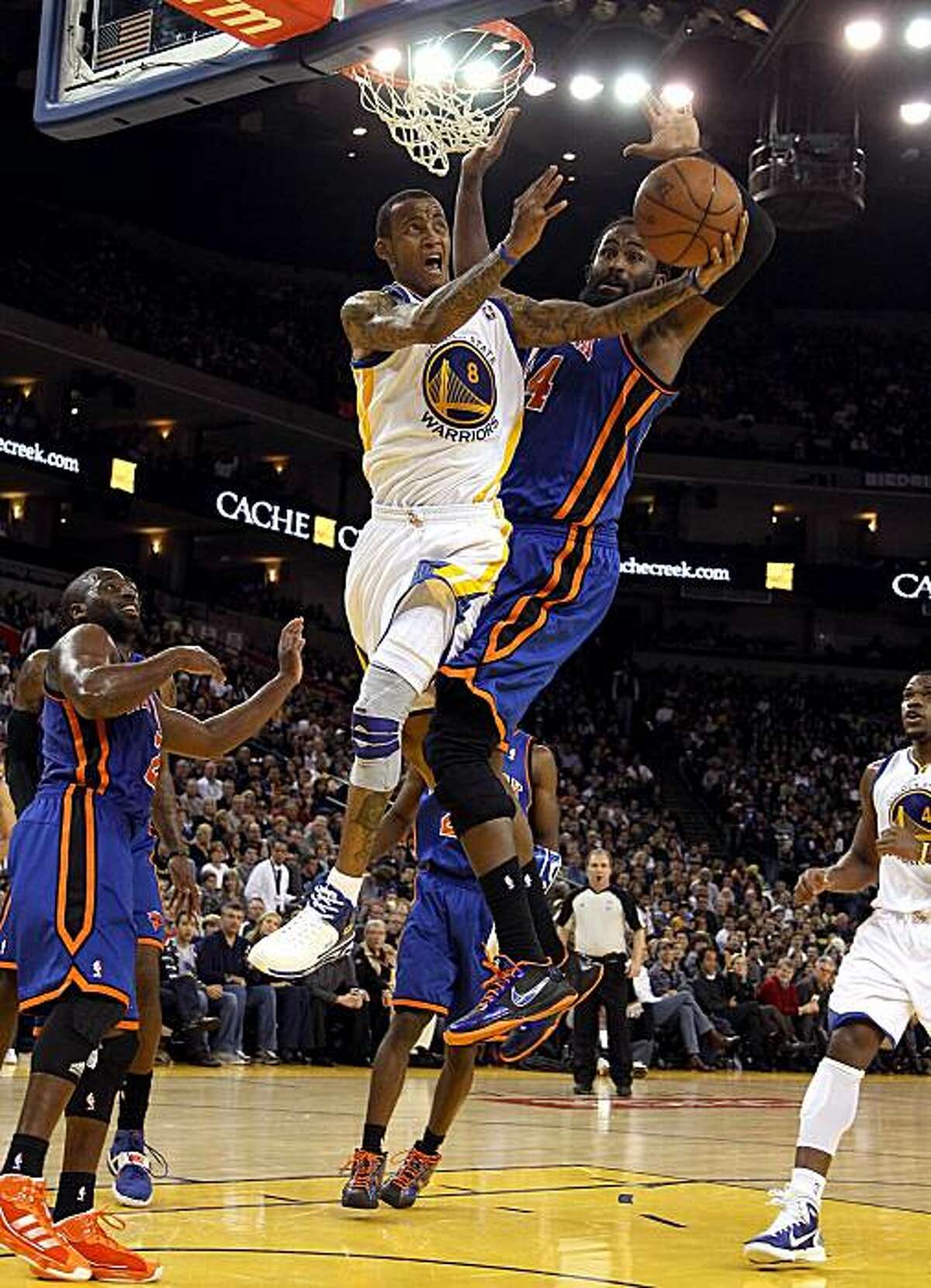 OAKLAND, CA - NOVEMBER 19: Monta Ellis #8 of the Golden State Warriors goes up for a shot while defended by Ronny Turiaf #14 of the New York Knicks at Oracle Arena on November 19, 2010 in Oakland, California. NOTE TO USER: User expressly acknowledges andagrees that, by downloading and or using this photograph, User is consenting to the terms and conditions of the Getty Images License Agreement.