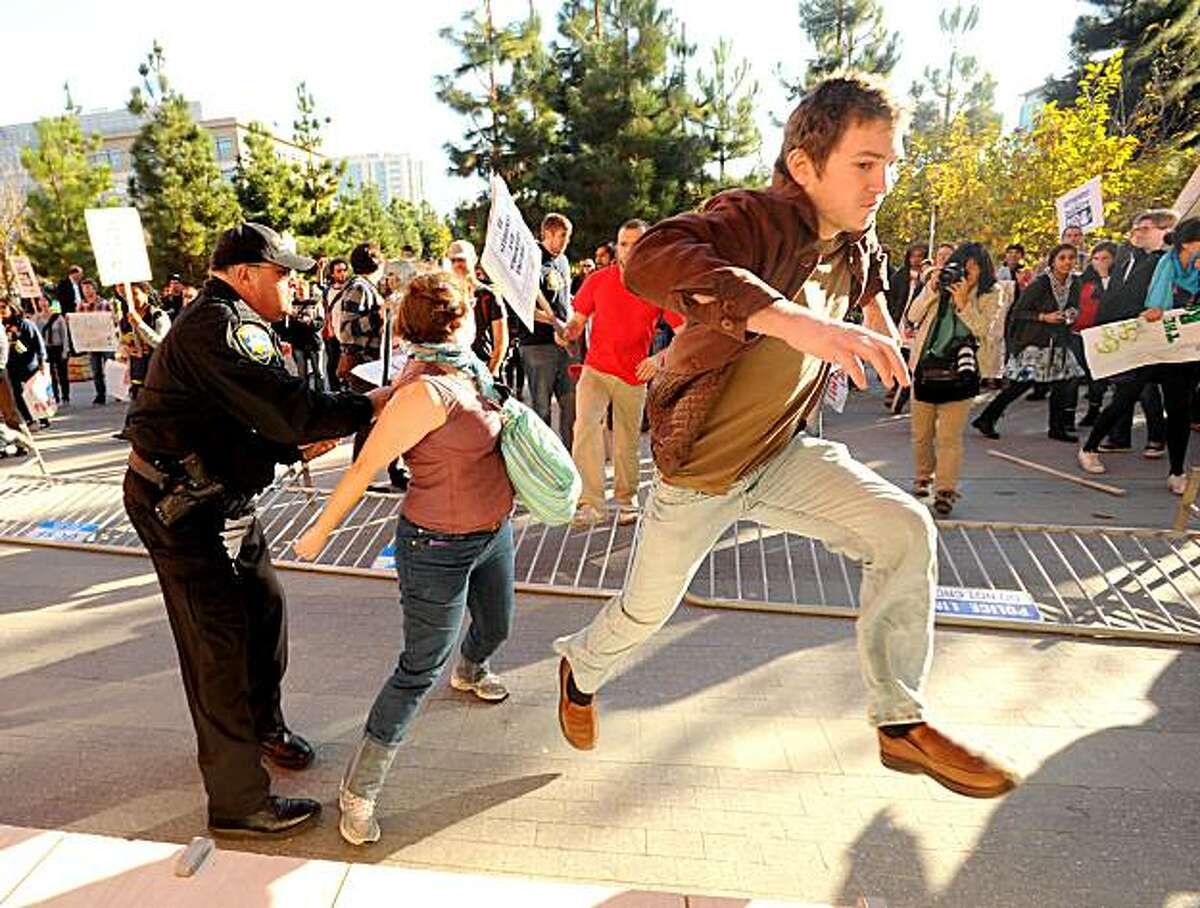 A protester attempts to enter a UC Regents meeting after fellow demonstrators knocked over police barricades on Wednesday, Nov. 11, 2010, in San Francisco.
