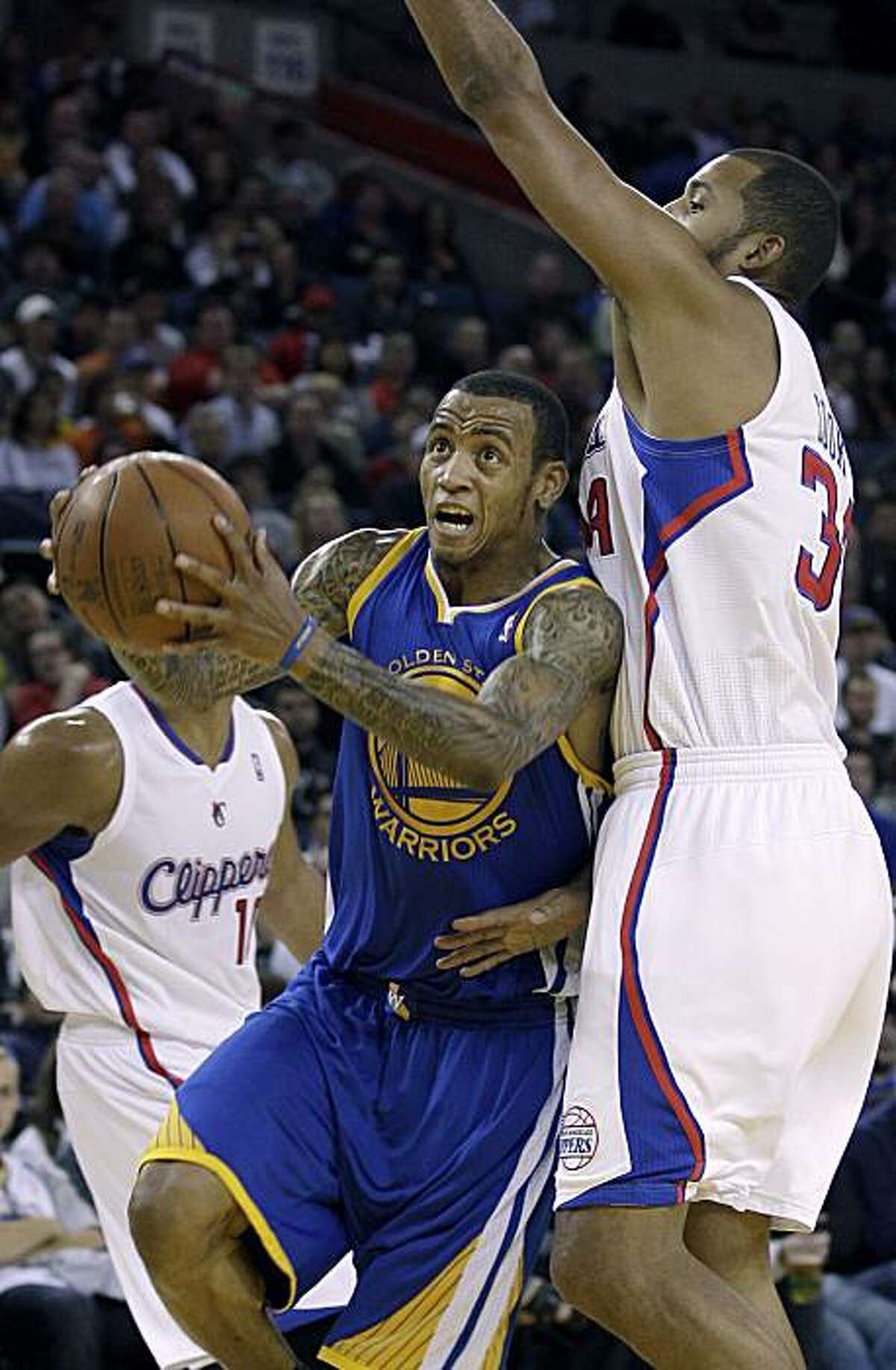 Golden State Warriors shooting guard Monta Ellis (8) drives past Los Angeles Clippers power forward Brian Cook (34) in the third quarter of an NBA basketball game in Oakland, Calif., Friday, Oct. 29, 2010.