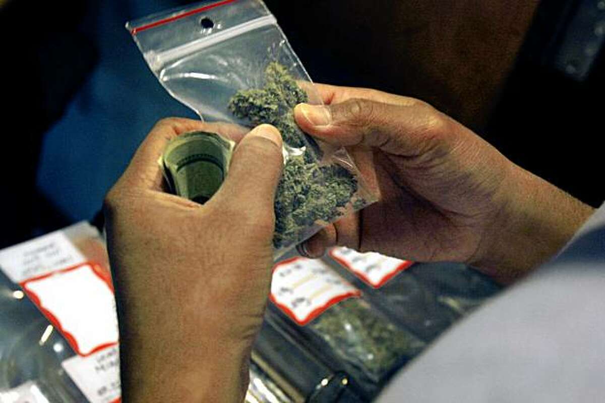 A patrons inspects a bag of marijuana while filling their medical marijuana prescription at the Coffeeshop Blue Sky in Oakland, Calif. on Monday October 19, 2009.