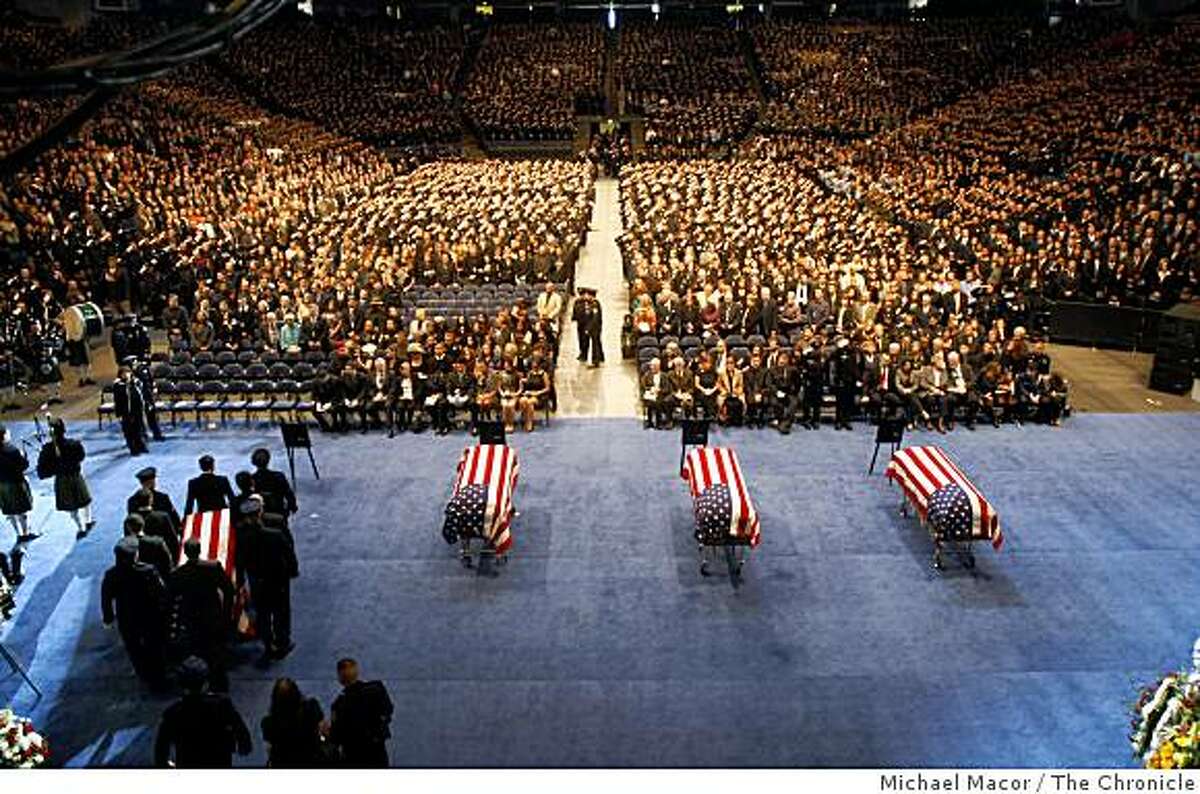 Police officers bring in the last of the flag-draped caskets of Oakland Police Officers Sgt. Mark Dunakin, 40; John Hege, 41; Sgt. Ervin Romans, 43; and Sgt. Daniel Sakai, 35, are carried by law enforcement officers into Oracle Arena on Friday, Mar. 27, 2009, in Oakland, Calif. Thousands of officers and firefighters from around the nation and overseas along with mourners turned out for Friday's funeral for the four veterans. The four officers were shot in the line of duty Saturday, March 21. (Michael Macor / San Francisco Chronicle, Pool)
