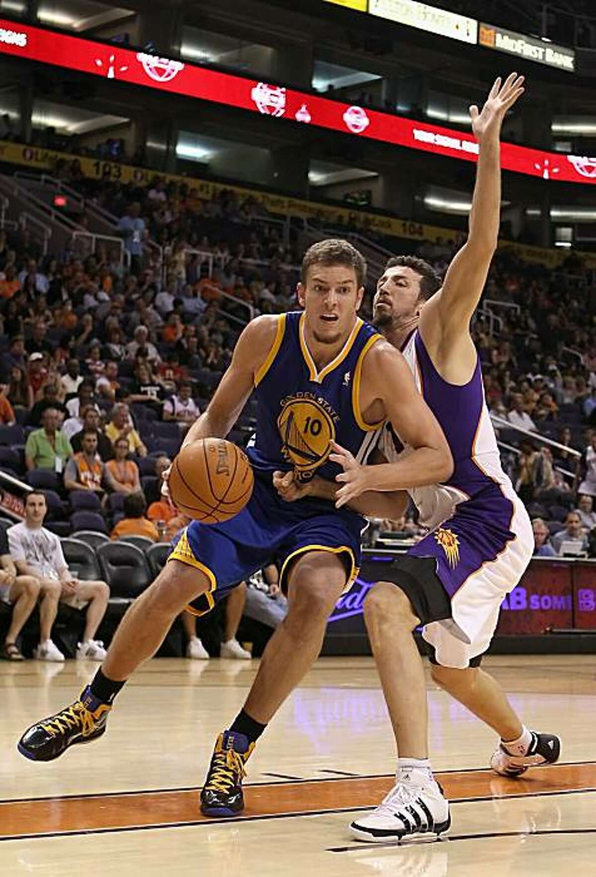 PHOENIX - OCTOBER 19: David Lee #10 of the Golden State Warriors handles the ball under pressure from Hedo Turkoglu #19 of the Phoenix Suns during the preseason NBA game at US Airways Center on October 19, 2010 in Phoenix, Arizona. NOTE TO USER: User expressly acknowledges and agrees that, by downloading and or using this photograph, User is consenting to the terms and conditions of the Getty Images License Agreement.