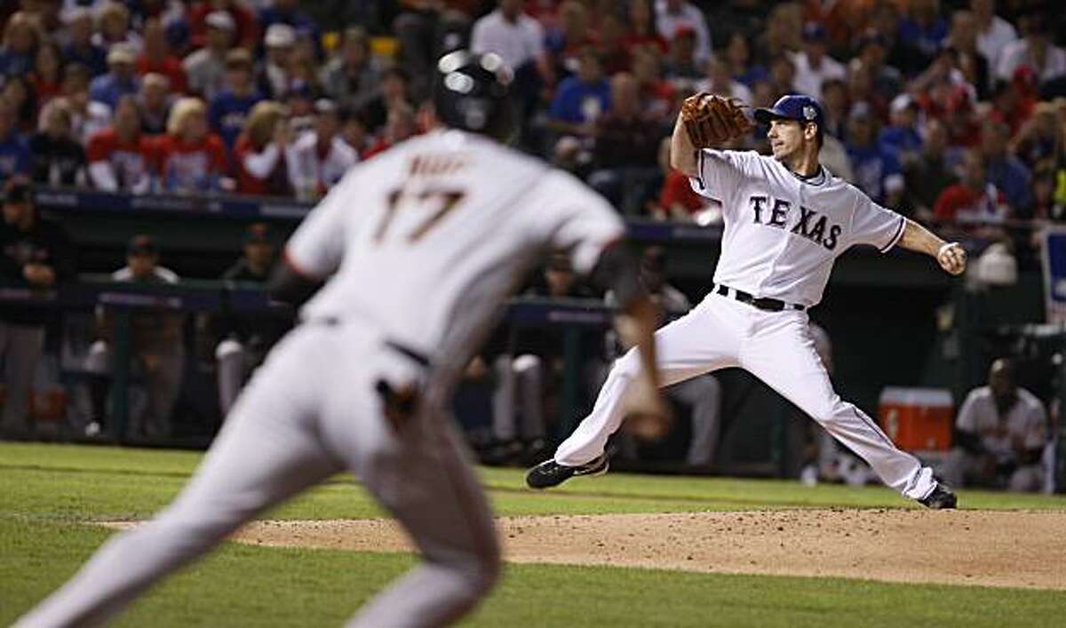 Texas Rangers starting pitcher Cliff Lee delivers a pitch as Aubrey Huff takes a lead in the fifth inning of Game 5 of the World Series on Monday.