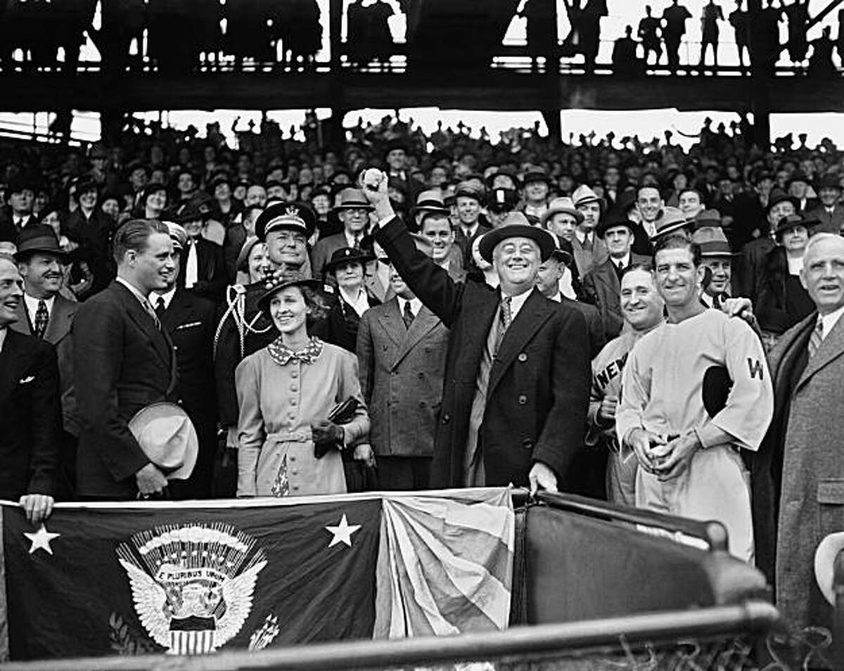 FILE - In this April 14, 1936 black-and-white file photo, President Franklin D. Roosevelt prepares to throw the traditional first pitch in Washington. A hundred years ago, a portly right-hander, President William Howard Taft threw out the first pitch at aWashington Senators game, a weak lob from the stands to the great Walter Johnson. On Monday, the Nationals bring in the left-hander, President Barack Obama.