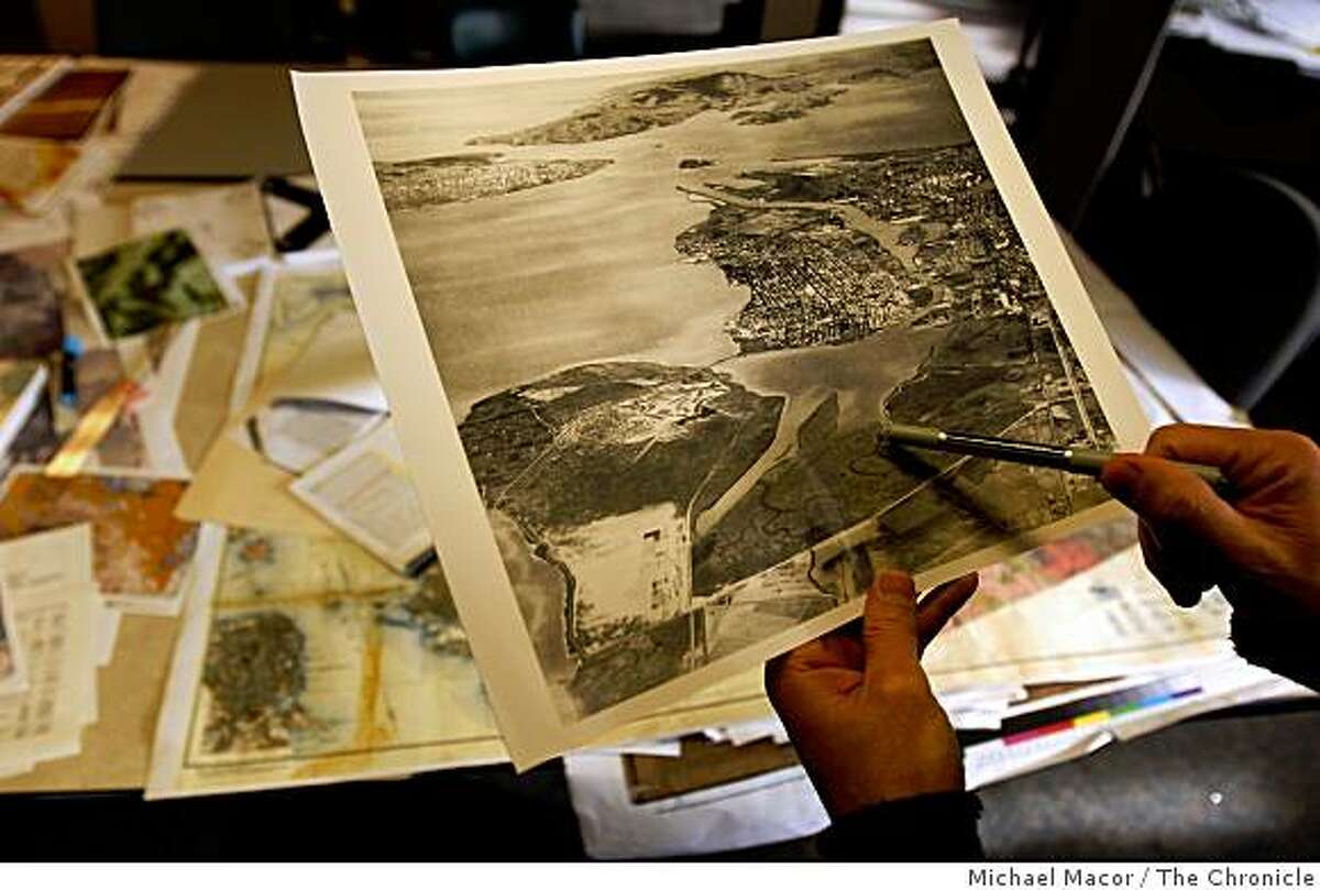 Robin Grossinger, holds a historical photo from the 1930's showing the wetlands around San Leandro Bay looked like some 80 plus years ago. Grossinger, at his Oakland, Calif. offices on Wednesday Feb. 25, 2009, Grossinger is a historical ecologist at the San Francisco Estuary Institute.