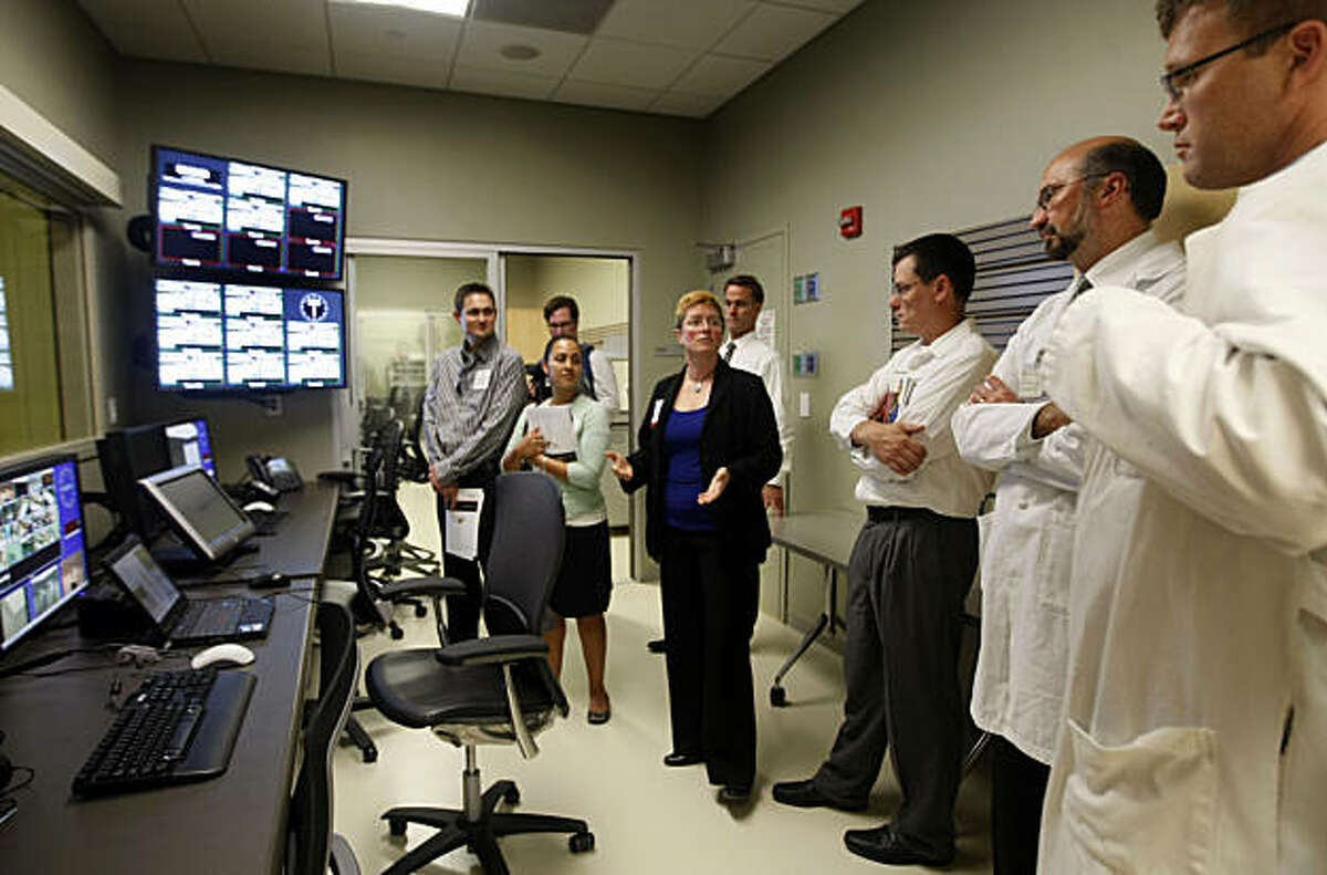 Kam McCowan (center0 a simulation Engineer at Stanford Medical School explains how the Emergency Operating Room uses high tech cameras and microphones. Stanford Medical School dedicated one of its new education centers Wednesday Sept 29, 2010. The Li Ka Shing Center, located next door to the hospital on Stanford Campus is a high tech medical school facility that is now open to students and facility. Hundreds of invited guest got to tour the facility, and see mock ER and ICU rooms as well as robot mannequin patients that can blink, breathe, cry, bleed and simulate diseases.