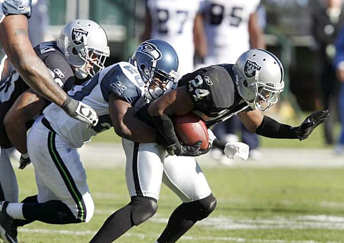 Michael Bush makes a fourth quarter gain and eventually scores a touchdown in the last minutes of the game against the Seattle Seahawks on Sunday at the Oakland Coliseum.