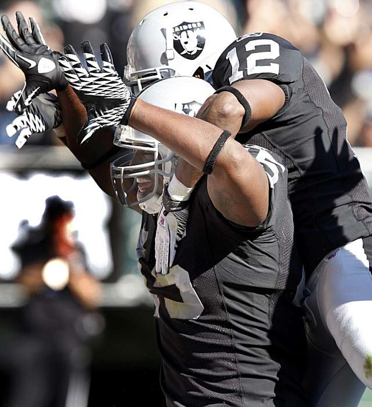 Marcel Reece (45) celebrates his second-quarter touchdown with Jacoby Ford on his back in the end zone Sunday at the Oakland Coliseum.