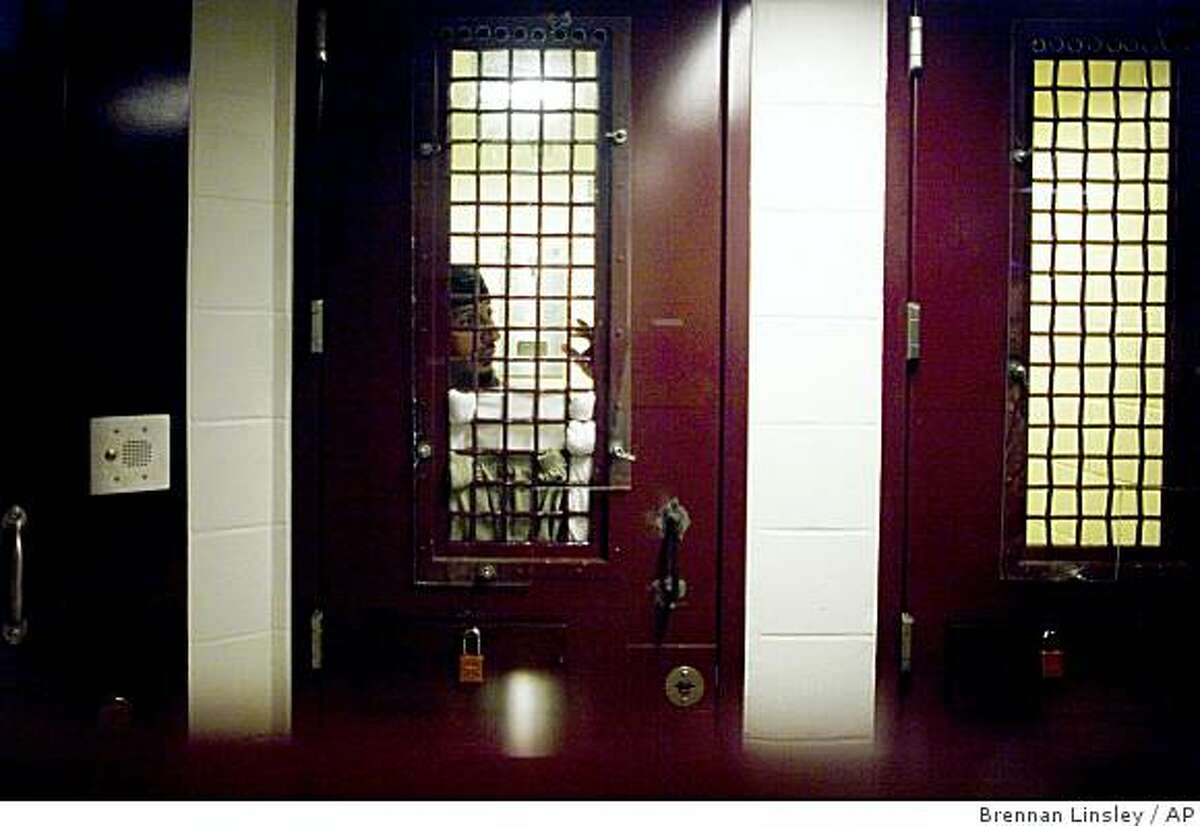 In this image reviewed by the U.S. Military, a Guantanamo detainee stands inside a holding cell, photographed through a glass wall, at Camp 5 detention facility, at the U.S. Naval Base, in Guantanamo Bay, Cuba, Nov. 19, 2008. A former Bush administration official said Thursday, March 19, 2009 that many detainees locked up at Guantanamo were innocent men swept up by U.S. forces unable to distinguish enemies from noncombatants. (AP Photo/Brennan Linsley)