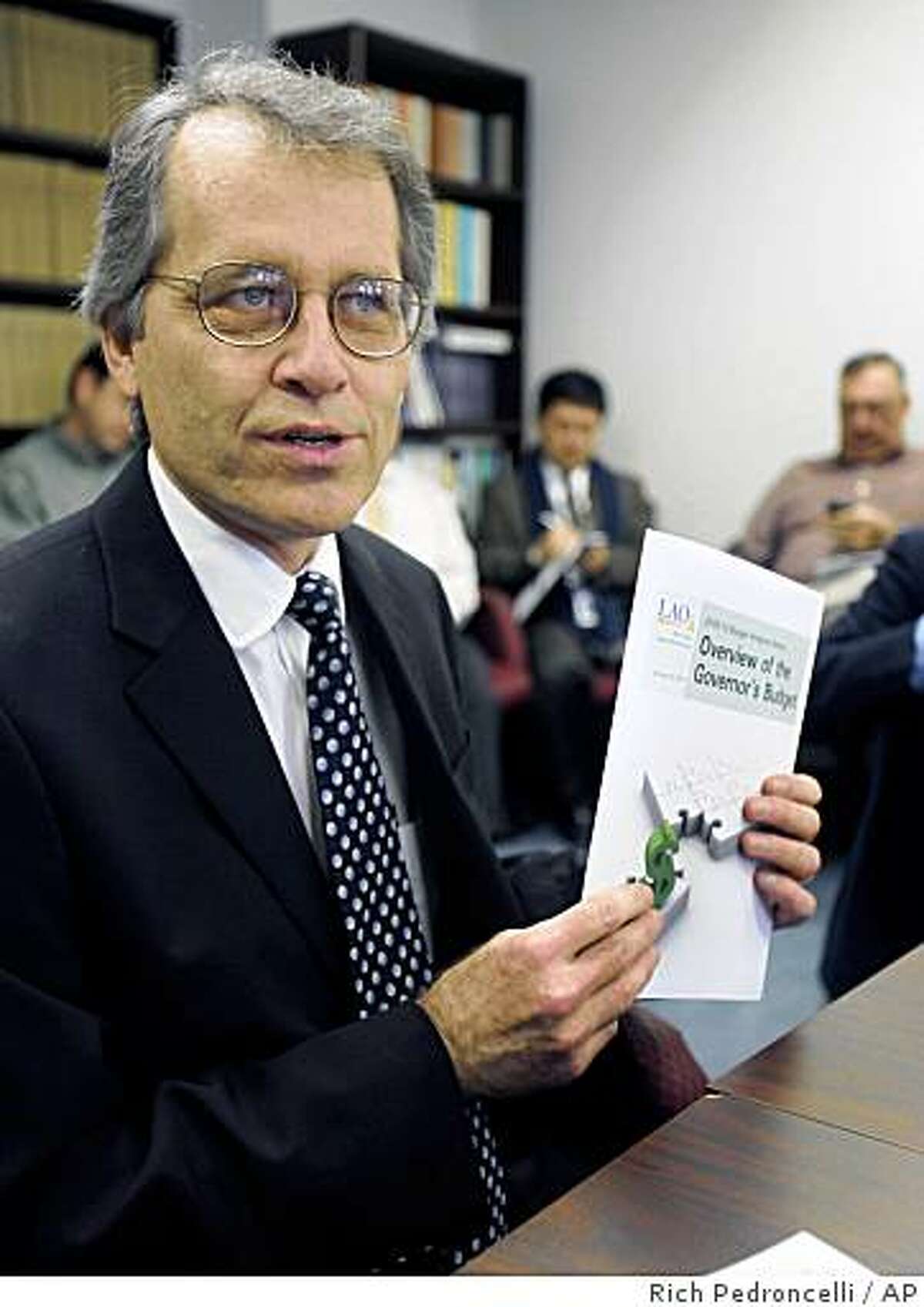 Legislative Analyst Mac Taylor displays a copy of his office's overview of Gov. Arnold Schwarzenegger's proposed 2009-10 state budget during a news conference in Sacramento, Calif., Thursday, Jan. 8, 2009.(AP Photo/Rich Pedroncelli)