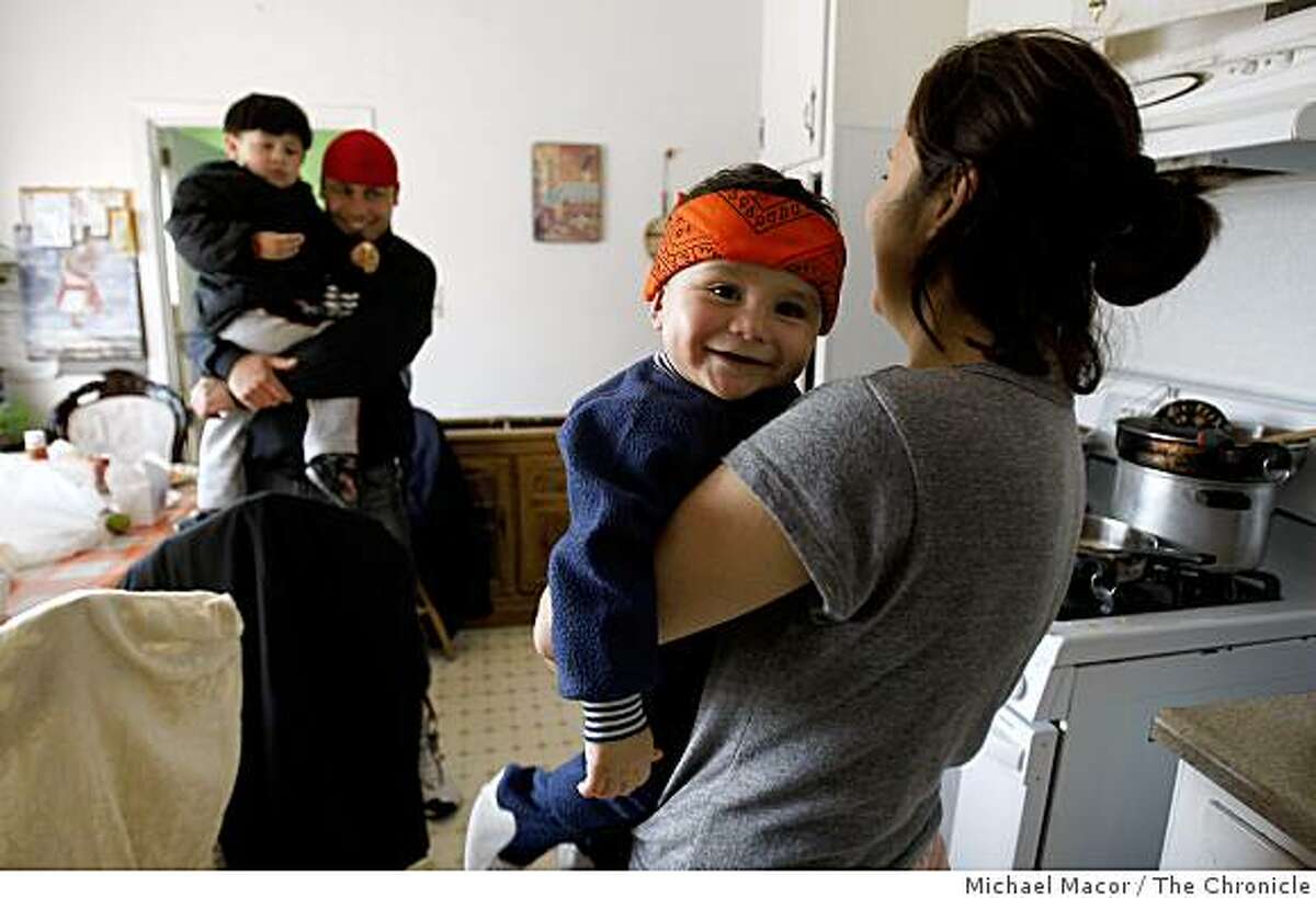 Adolfo Peregrina with his son Adolfo Jr., 2-years-old and his wife Carmen with their 10 month old son Jonathan in the kitchen of his San Pablo, Calif. home on Thursday Mar. 5, 2009. Peregrina has missed the last 6 mortgage payments on his home due to declining work in the construction business. He hopes that President Obama's housing rescue plan can help him hold onto his home.