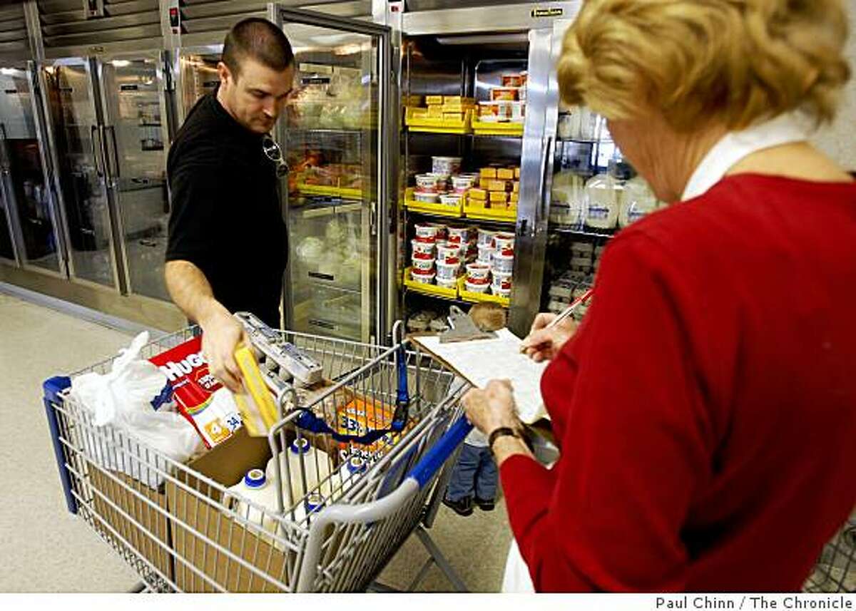 A store volunteer (right) helps Jon Isom select his groceries at the Bishop's Storehouse in Concord, Calif., on Wednesday, Feb. 25, 2009. Operated by the Latter-Day Saints, the storehouse provides food and provisions to church members in need.