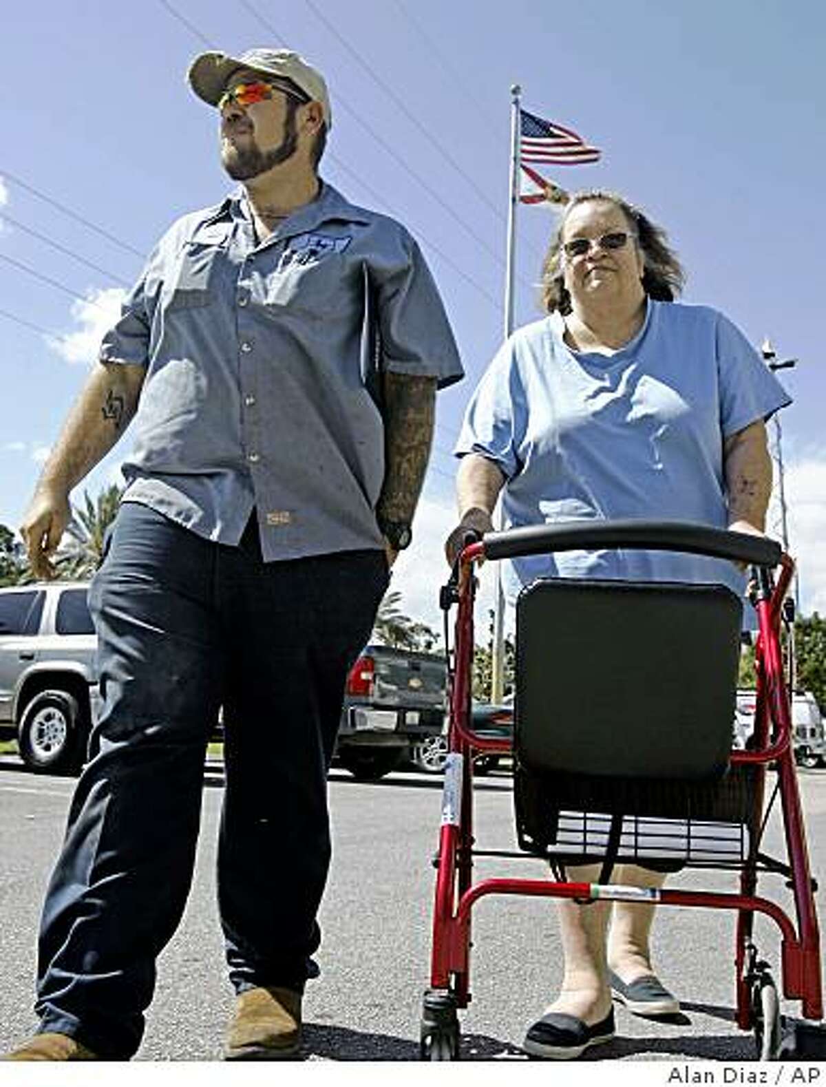 Bonnie Bigger, 60 (right) and her son Jason, 29, walk to their car after attending a foreclosure workshop in Fort Pierce, Fla., on Friday. Their lender began foreclosure proceedings against them for falling $4,500 behind on their $776-a-month mortgage payments on a condo they have been living in since 1984.