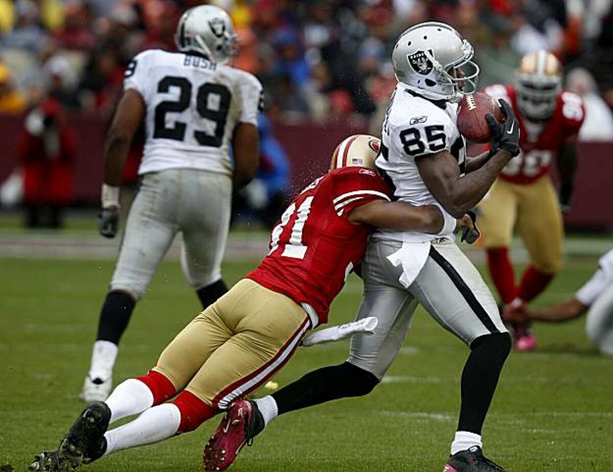 William James of the 49ers catches the Raiders' Darrius Heyward-Bey after a short gain in the first half Sunday at Candlestick Park.