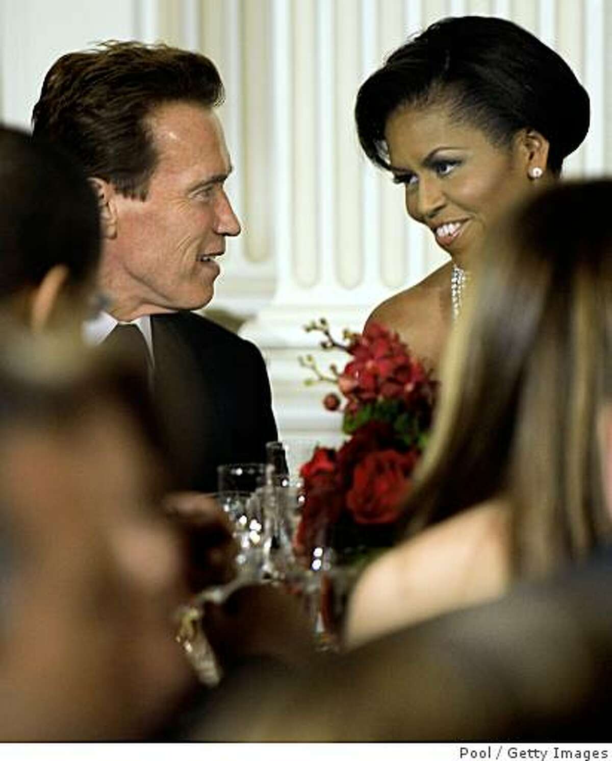 California Governor Arnold Schwarzenegger sits next to first Lady Michelle Obama at a black-tie dinner at the White House on Feb. 22, 2009 in Washington, D.C. The Obamas gave their first formal White House dinner as hosts to the National Governors Association, which was been holding their 2009 winter meeting discussing Obama's stimulus program, health care, infrastructure and education.