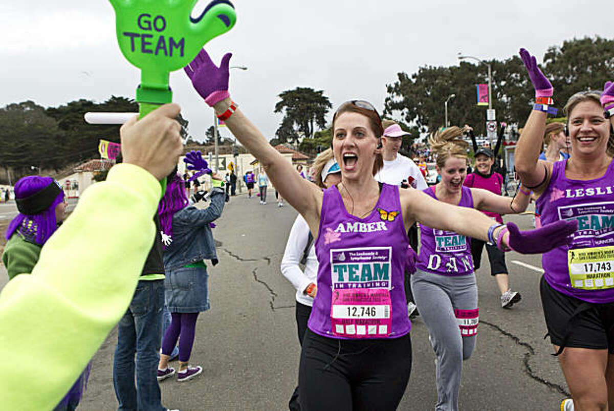 Runners get a high five while running along Marina Boulevard during the Nike Women's Marathon in San Francisco, Calif., on Sunday, October 17, 2010.