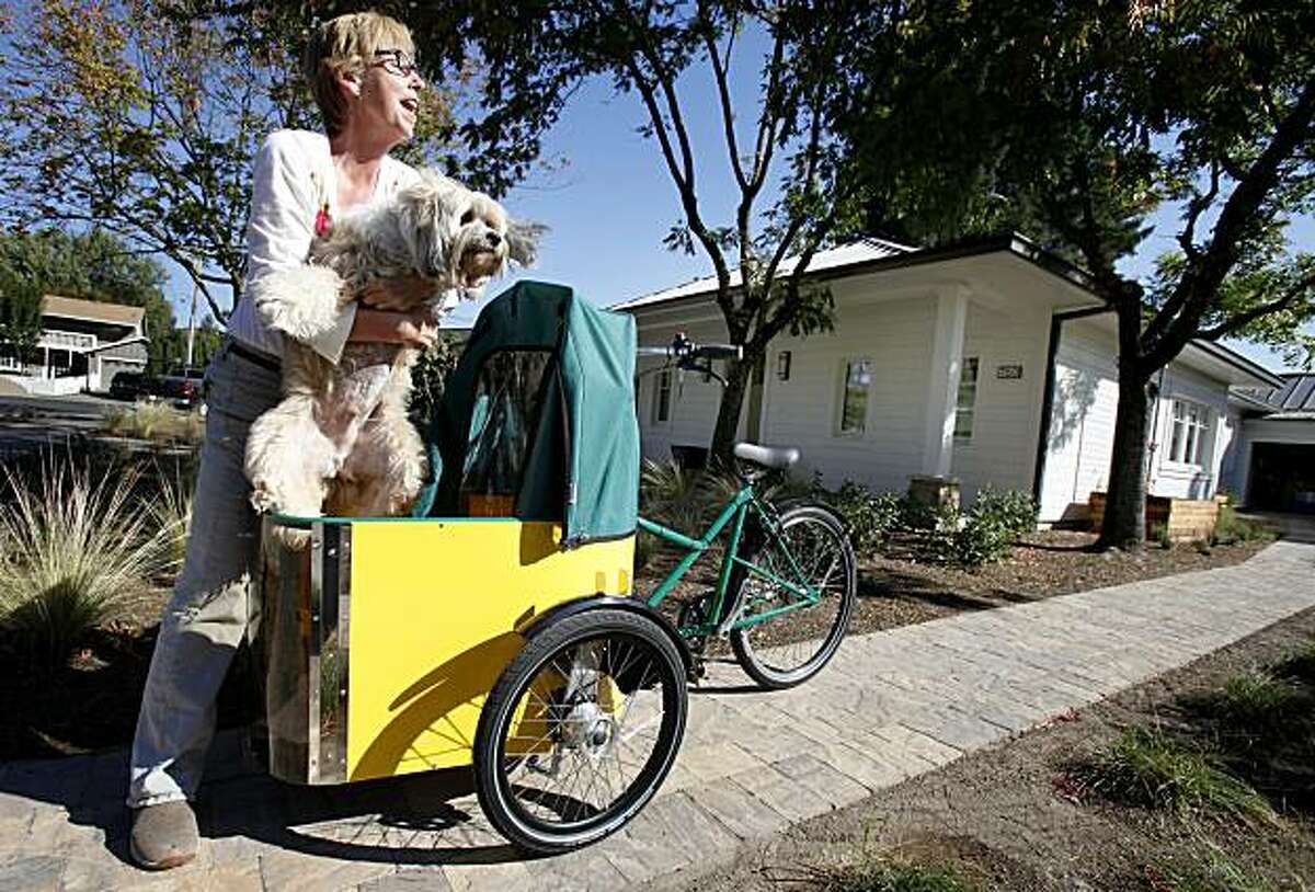 Cathy O'Neill, the home owner, puts her dog Max O'Neill into the special dog carrier she has on her bike Thursday October 14, 2010. California's first "passive" home is a 2400 square foot masterpiece in Sonoma, Calif. The home uses a design popular in Europe which reduces energy consumption by 90 percent.