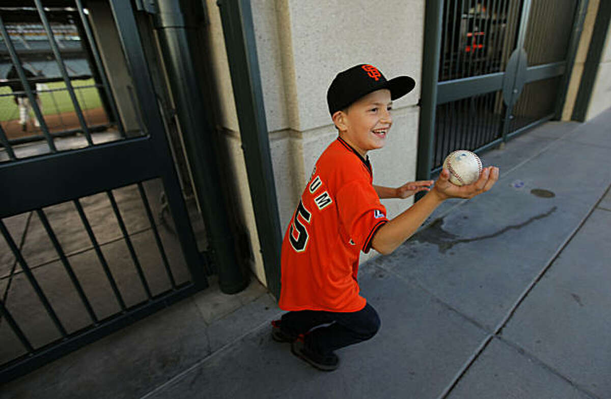 10-year-old Rod Cardoza, of San Jose, shows off a baseball from Ramon Ramirez, as he watched through the right field fence, the San Francisco Giants hold a batting practice at AT&T Ball Park, on Tuesday Oct. 4, 2010, in preparation for the National League Divisional Series which is set to get underway later this week.