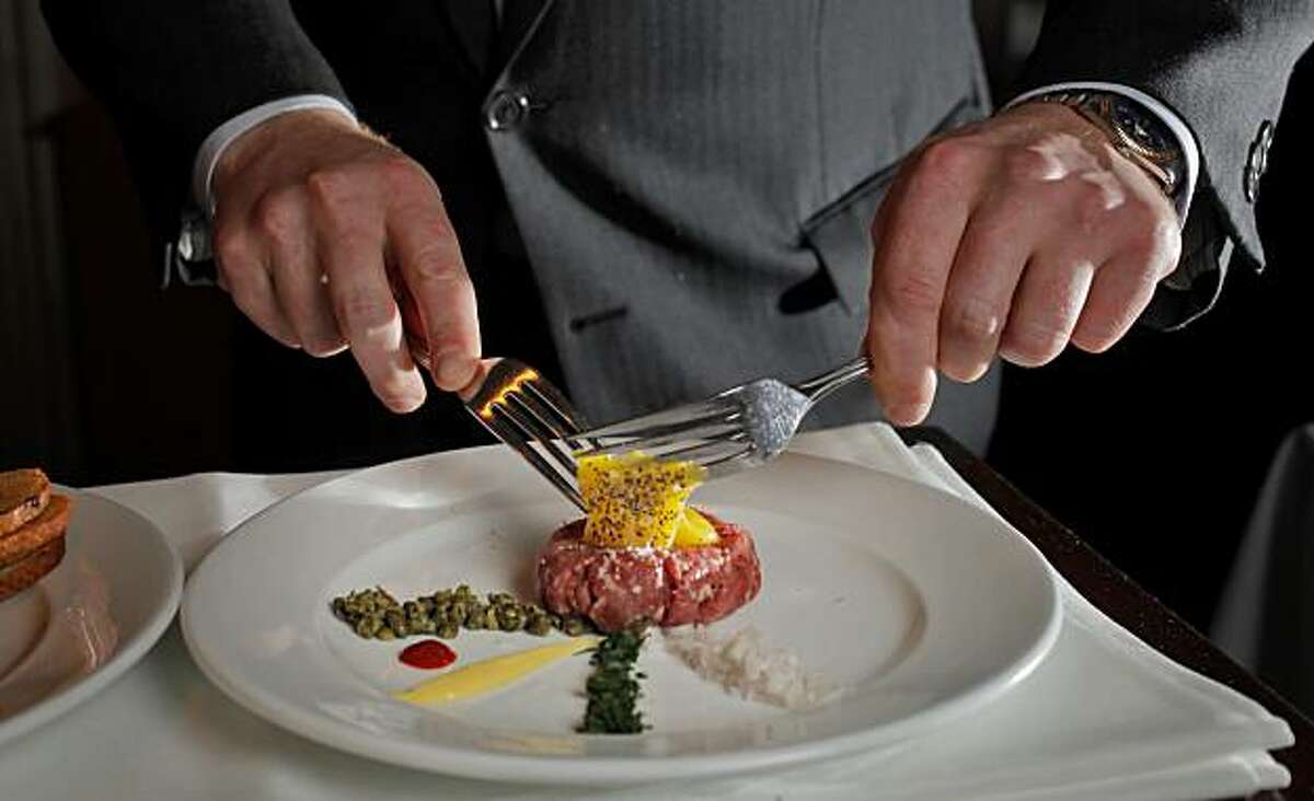 Blake Tippett, manager of Bix restaurant, mixes the egg with the cropped New York steak as he prepares steak tartare, Monday Sept. 20, 2010, in San Francisco, Calif.