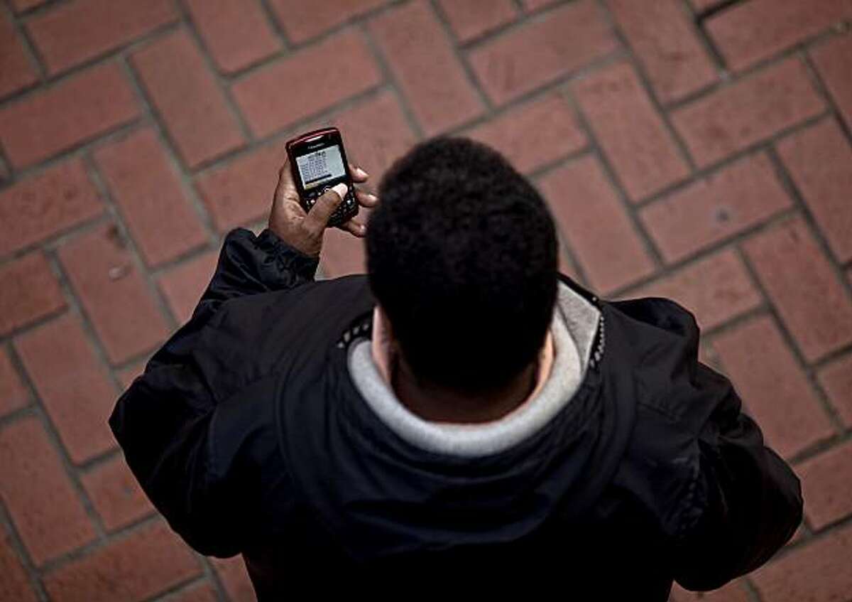 Using a device on Market Street on Saturday January 30, 2010, in San Francisco, Calif. Orthopedic Doctors are increasingly seeing injuries from people using smartphones, mainly from people slumping over to use the devices.
