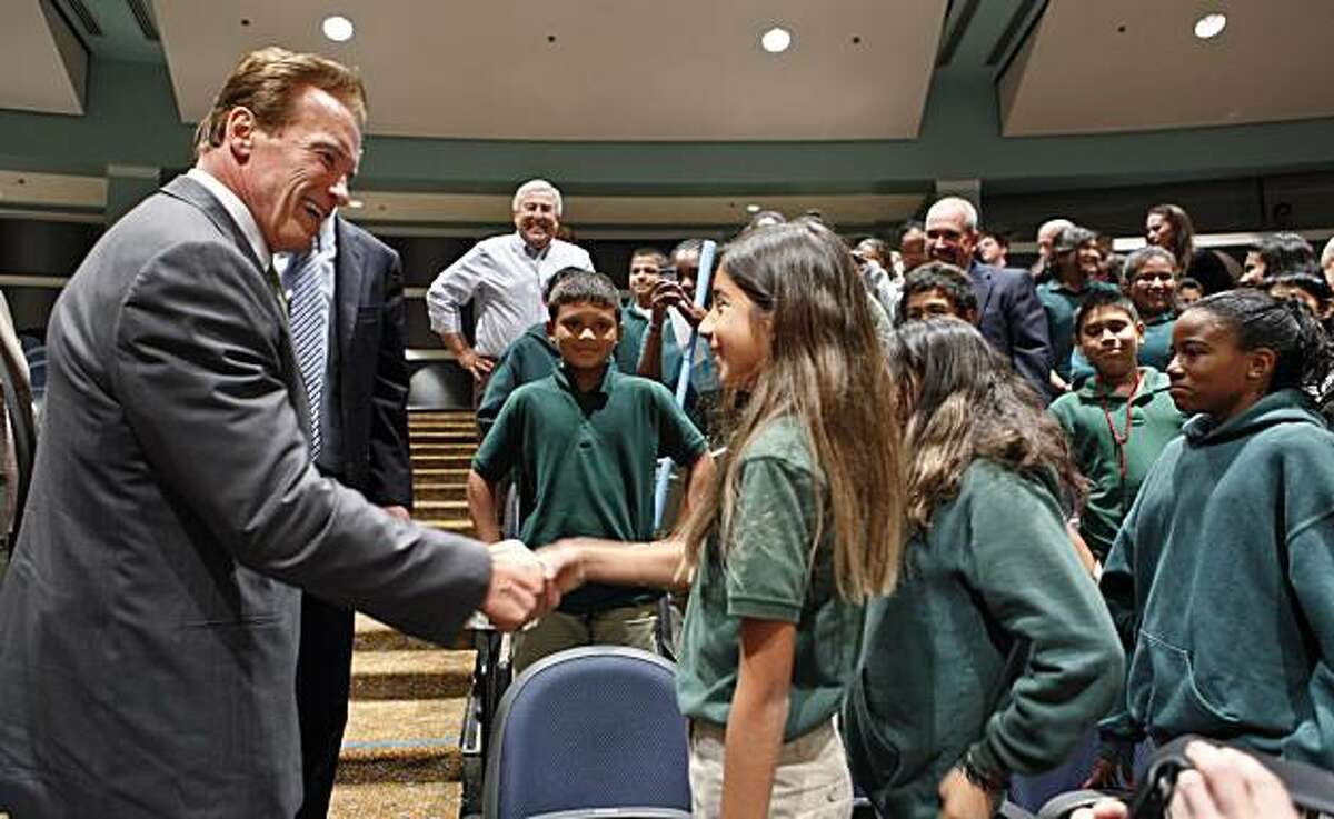 Gov. Arnold Schwarzenegger, left, shakes hands with students from Beechwood School in Menlo Park, Calif., after he spoke at the Commonwealth Club in Santa Clara, Calif., Monday, Sept. 27, 2010. Schwarzenegger is blasting the oil companies that are tryingto undermine California's global warming law, saying they are motivated purely by greed.