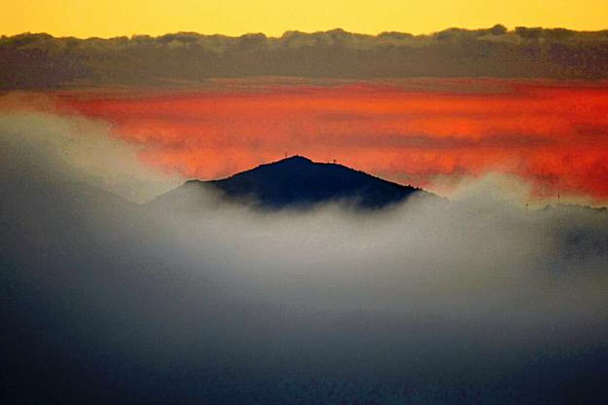 Heavy fog covers the Bay Area in different layers of hue leaving only the tallest peak of Mount Diablo visible from Hawk hill in the Marin Headlands just before sunrise on Tueday, October 28, 2008.