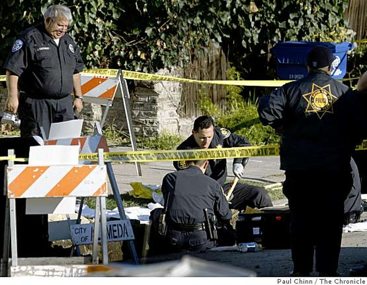 Investigators search for more evidence after a road maintenance crew discovered human remains buried in mud on the 3000 block of Washington Street in Alameda, Calif., on Wednesday, Jan. 28, 2009.