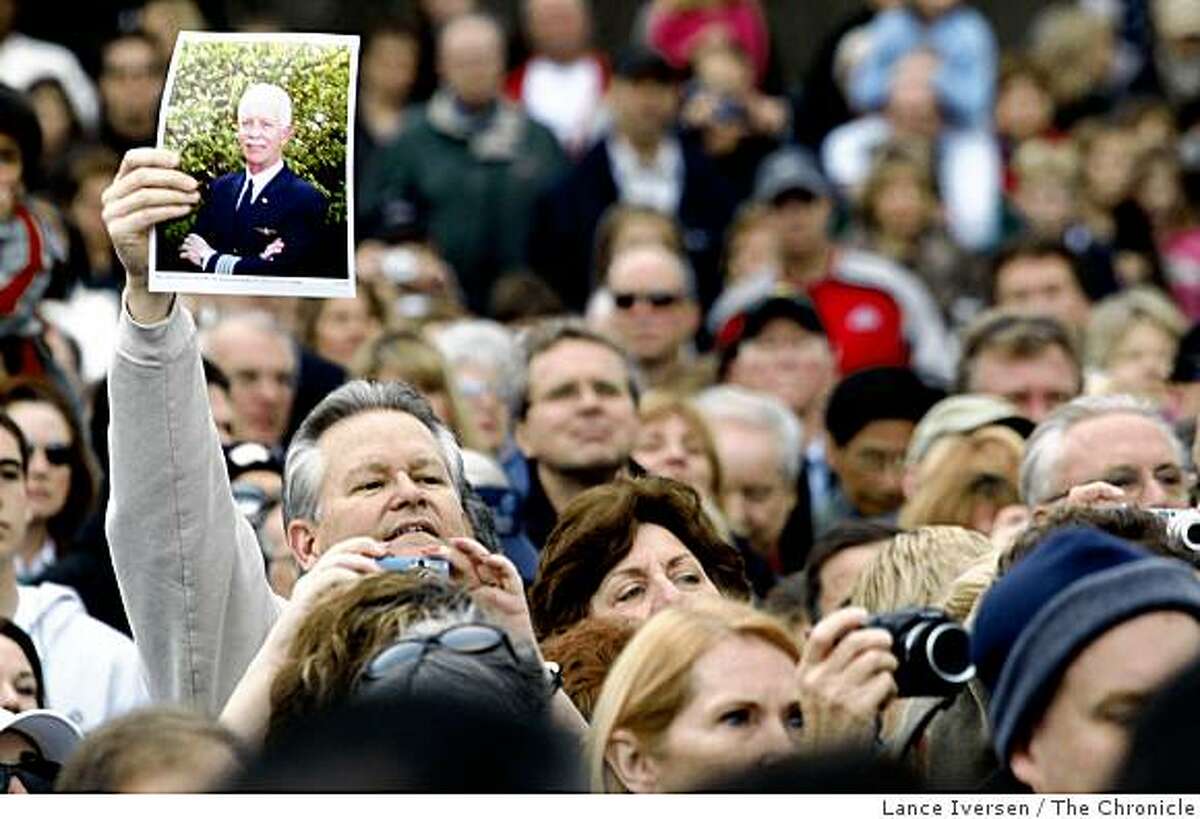 A man holds up a photo of US Airways Captain Chesley "Sully" Sullenberger III as he and several thousand gathered in front of the Danville Library Saturday, Jan 24, 2009 to honor the hero of the Hudson.