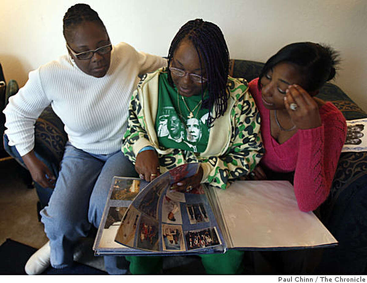 Carol Frazier, looks at family photos with her daughters Taneya Talley, center, and Shameana Talley at their home in Vallejo, Calif., on Wednesday, Nov. 26, 2008. Frazier's other daughter Taneka Talley was fatally stabbed to death in 2006 but Talley's insurance company is refusing to pay benefits to her son claiming the murder was racially motivated.