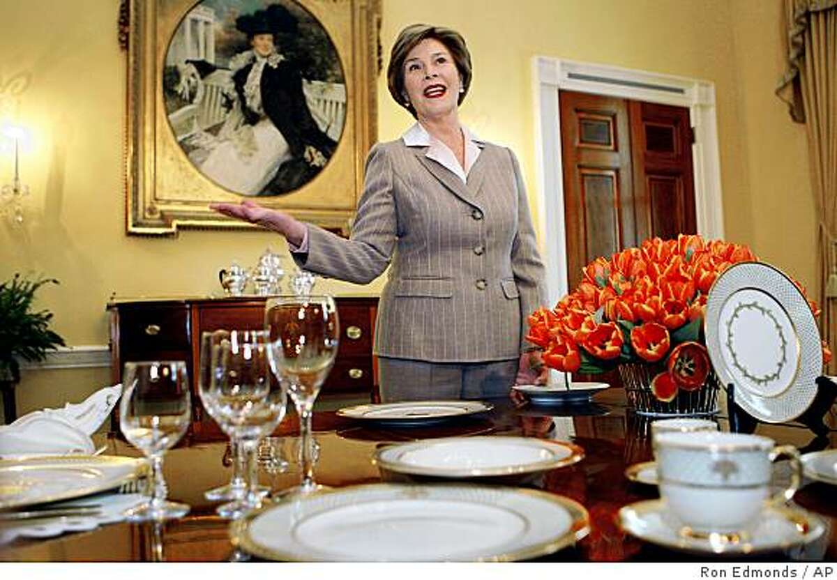 First lady Laura Bush gestures while showing off some of the new White House China Service, Wednesday, Jan. 7, 2009, in the Old Family Dining Room of the White House in Washington. (AP Photo/Ron Edmonds)