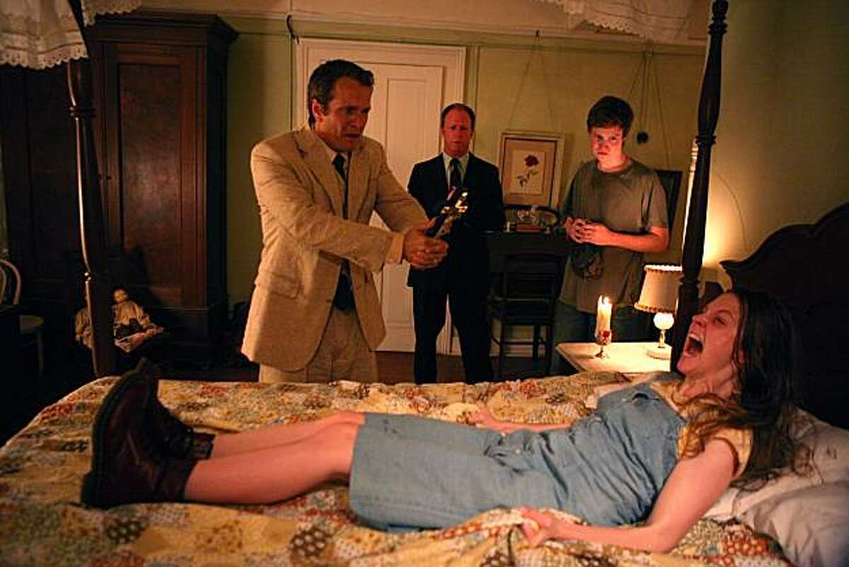 Nell Sweetzer (Ashley Bell, front), Cotton Marcus (Patrick Fabian, left), Louis Sweetzer (Louis Herthum, center), and Caleb Sweetzer (Caleb Landry Jones, right) in THE LAST EXORCISM.