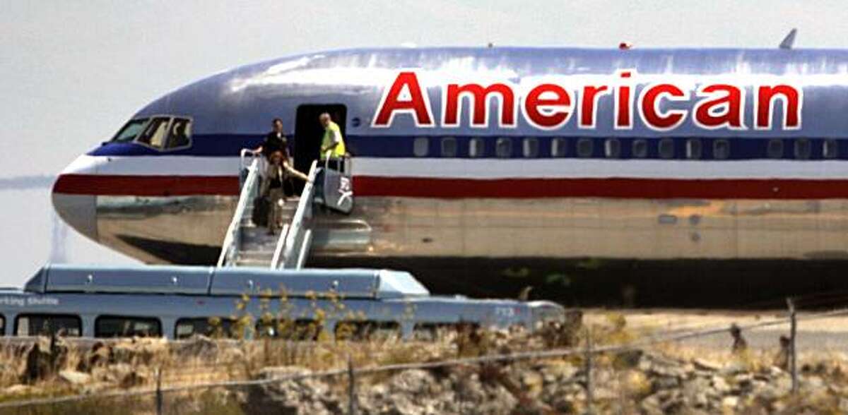 A passenger aboard American Airlines Flight 24, a Boeing 767 with 163 passengers and 11 crewmembers walks down the portable ladder. The jetliner sat on a San Francisco International Airport runway for hours as authorities including the FBI conducted a search after a verbal phone threat. The nature of the threat has not been disclosed. Two people have been detained and passenger were removed along with their baggage and returned to the terminal as the investigation continued. Thursday August 19, 2010.
