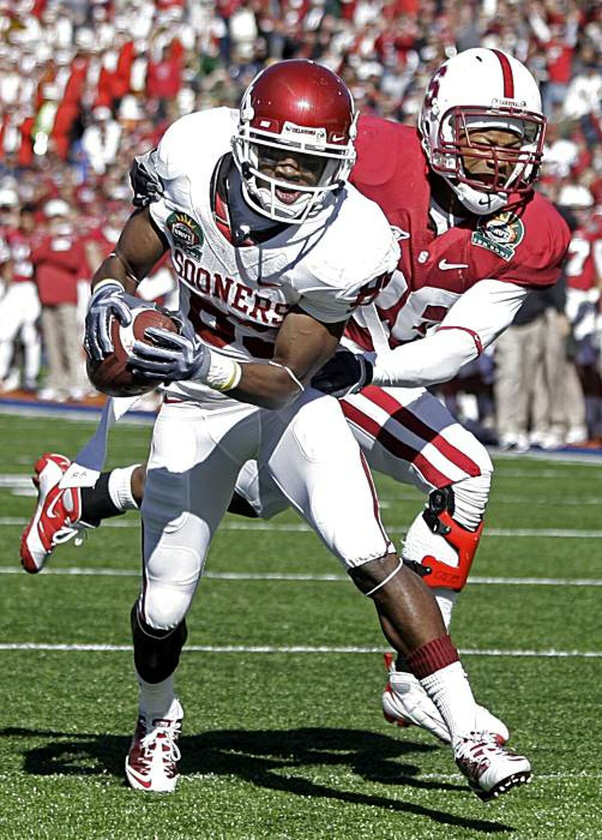 Oklahoma wide receiver Ryan Broyles (85) scores a touchdown as Stanford safety Delano Howell (26) defends during the first half of the Sun Bowl NCAA colllege football game in El Paso, Texas, Thursday, Dec. 31, 2009. (AP Photo/LM Otero)