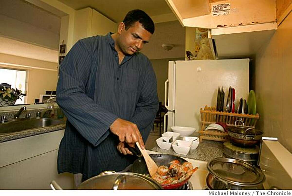 Amber India corporate chef Vittal Shetty prepares coconut shrimp curry in the small kitchen of his San Jose, Calif., apartment on December 3, 2008.