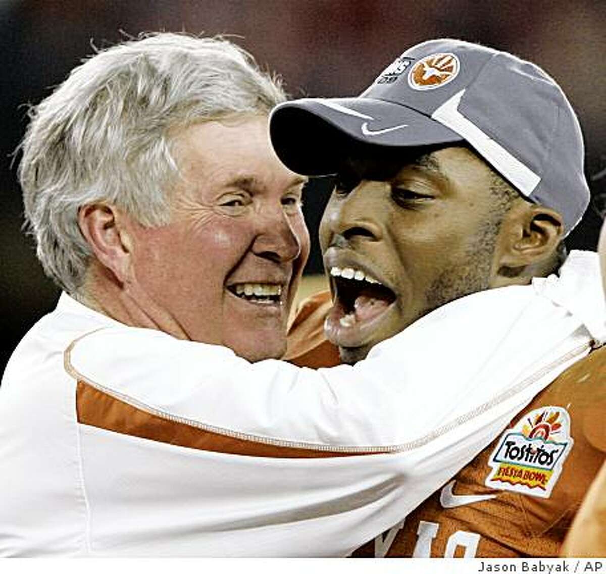 Texas coach Mack Brown, left, hugs tackle Roy Miller after Texas defeated Ohio State 24-21 in the Fiesta Bowl Monday, Jan. 5, 2009, in Glendale, Ariz.