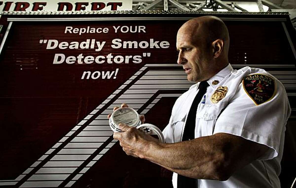 Albany Fire Chief Marc McGinn, holds a photoelectric smoke detector at the Albany FIre Station in Albany, Calif. on Tuesday August 10, 2010. McGinn is calling for the immediate removal of what he claims are fraudulent, ?’deadly?“ ionization so-called smoke alarms from all stores and homes in America and replacing them with photoelectric devices.