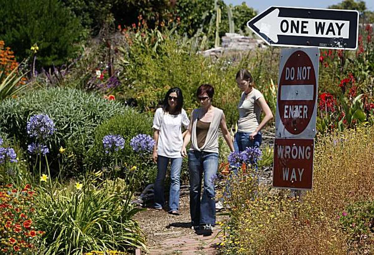 Arum Ahn (left), Annie Shaw (center) and Emily Gogol visit the Pennsylvania Avenue Garden in San Francisco, Calif., on Friday, July 16, 2010. The three Potrero Hill neighbors organized a community effort to start up and maintain the garden which is located next to the Mariposa Street off-ramp from Interstate 280.