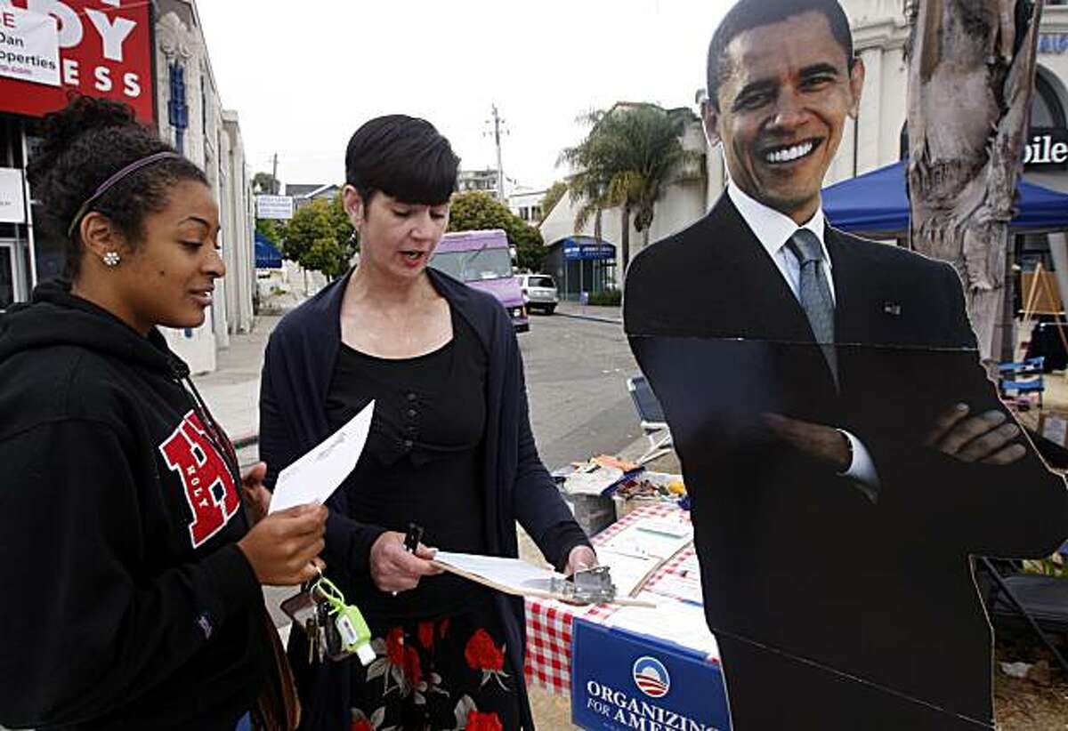 Jacqueline Collins (right), with the political action group Organizing For America, helps Taylor Newman register to vote at the Grand Lake Farmers Market in Oakland, Calif., on Saturday, July 31, 2010.