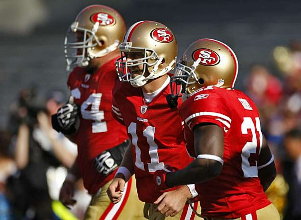 San Francisco 49ers quarterback Alex Smith (center) walks between David Bass(left) and Frank Gore(right) during the game against the Titans, Sunday Nov. 8, 2009, in San Francisco, Calif.
