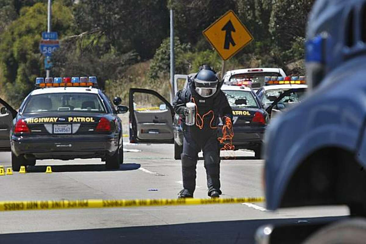 Alameda County Bomb Squad St. Ray Kelly prepares to detonate two suspicious packages from a white Toyota truck on I-580 in Oakland on Sunday, after a shootout Saturday night involving two CHP officers and a man wearing body armor.