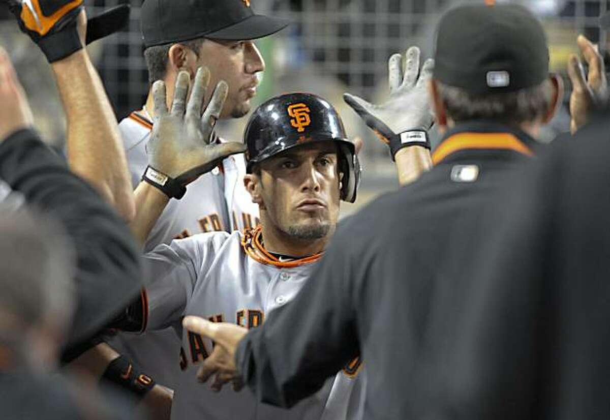 San Francisco Giants center fielder Andres Torres celebrates with his team in the dugout after scoring in the ninth inning of a baseball game against the Los Angeles Dodgers, Tuesday, July 20, 2010, in Los Angeles. The Gaints won 7-5.