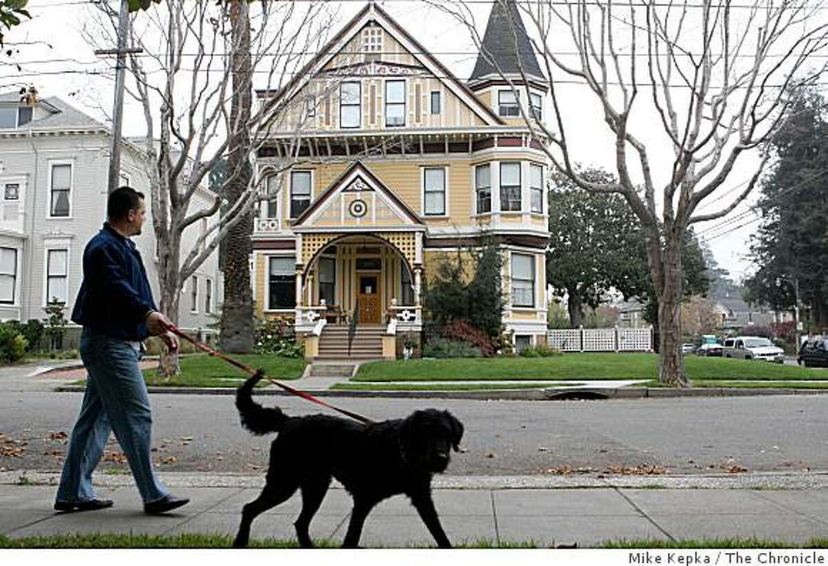 Jason Pollard and his dog Rosie go for their daily walk past a grand looking victorian home in an area called The Gold Coast on, Friday Nov. 28, 2008 in Alameda, Calif. Ran on: 12-07-2008 Ran on: 12-07-2008