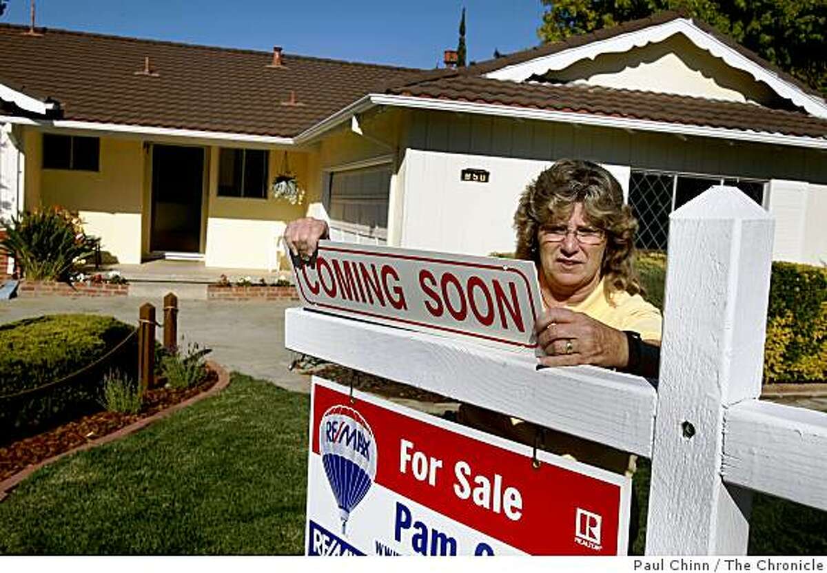 Realtor Pam Cole hangs a sign in front of a house about to hit the market at $495,000 in Livermore, Calif., on Thursday, Nov. 6, 2008. Home prices per square foot in Livermore's 94550 ZIP code, where this three-bedroom, two-bath property is located, are down 17 percent compared to last year which represents the midpoint of price changes in the Bay Area.